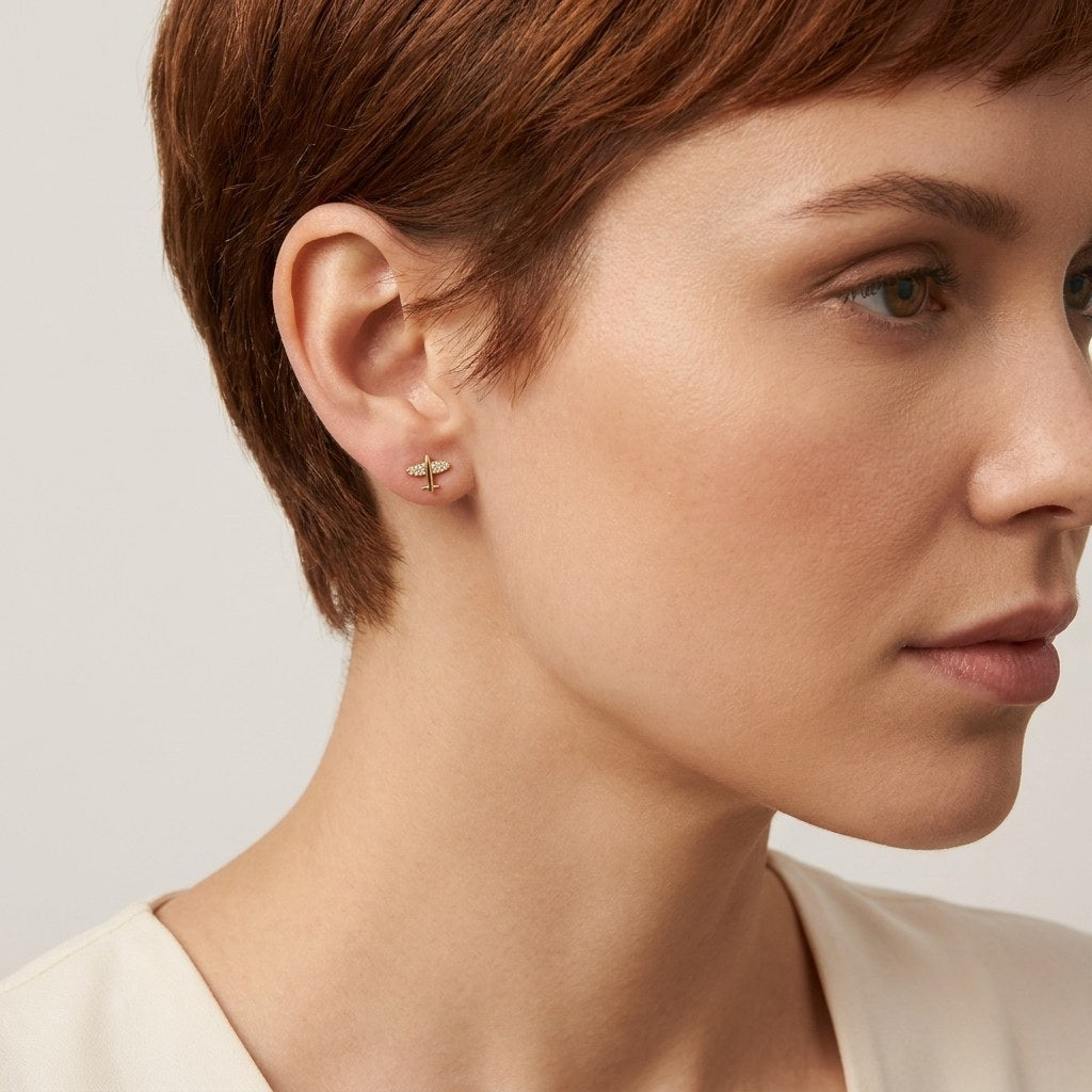 14K solid gold crystal saturn stud earrings worn on an ear