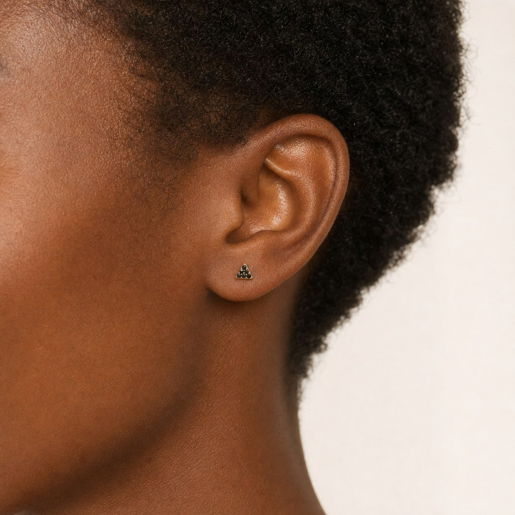 14K solid gold black pave triangle stud earrings worn on an ear
