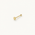 Solid Gold Flat Disc Nose Stud in yellow gold on a warm ivory background